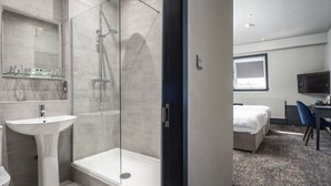 A modern bathroom with a glass-enclosed shower, a pedestal sink, and a toilet. - Coachman Hotel (Glasgow)