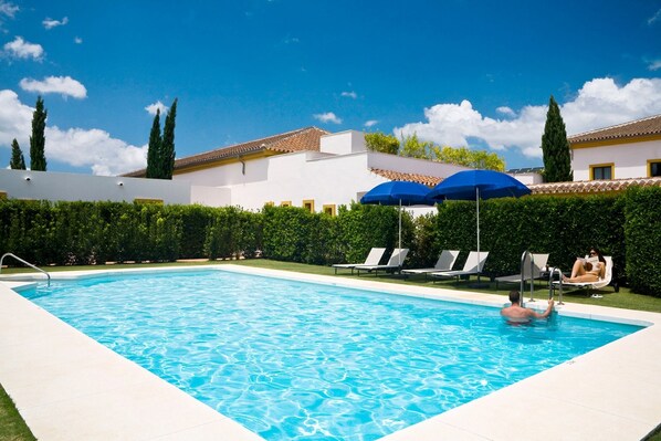 Piscina externa sazonal, funciona das 10h às 20h, guarda-sóis