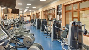 Un gimnasio con cintas de correr, elípticas y máquinas de pesas.