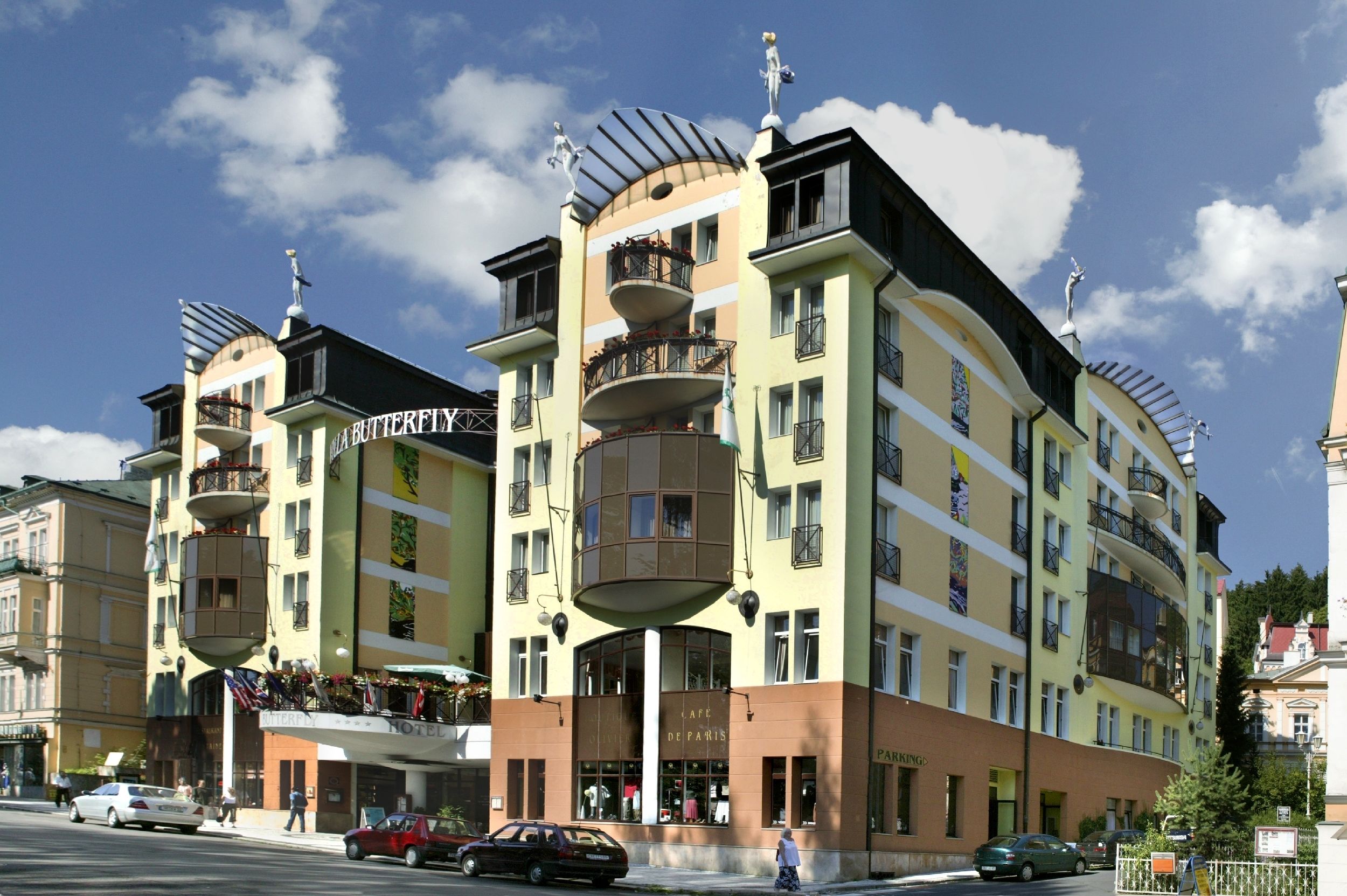 A multi-story hotel with balconies, a central courtyard, and a sign indicating it is a hotel.