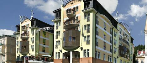 A multi-story hotel with balconies, a central courtyard, and a sign indicating it is a hotel.