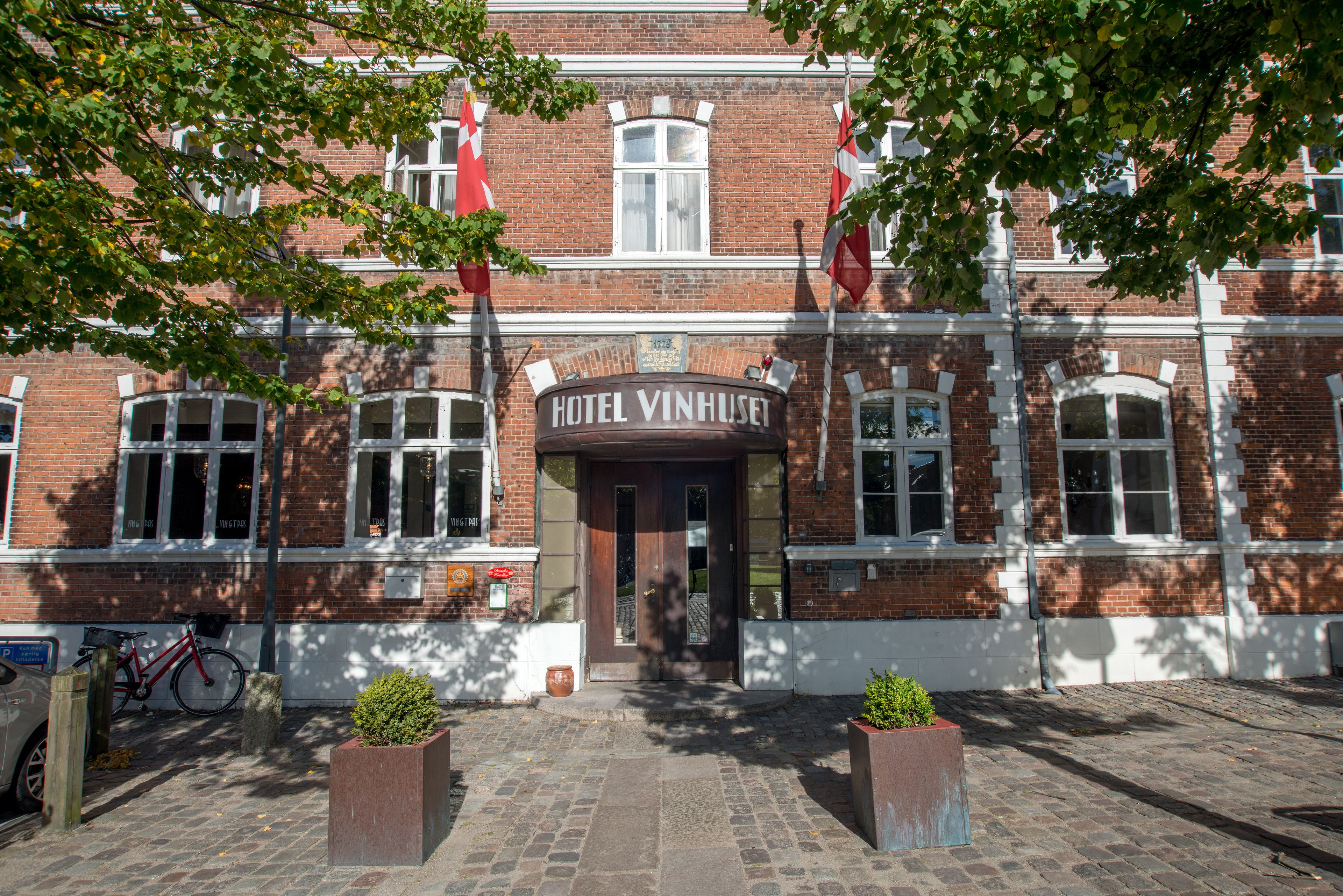 Un edificio histórico con un cartel que dice "HOTEL VINHUSET".