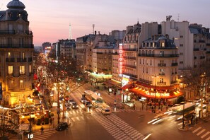 Un paisaje urbano con un teatro destacado y edificios circundantes.