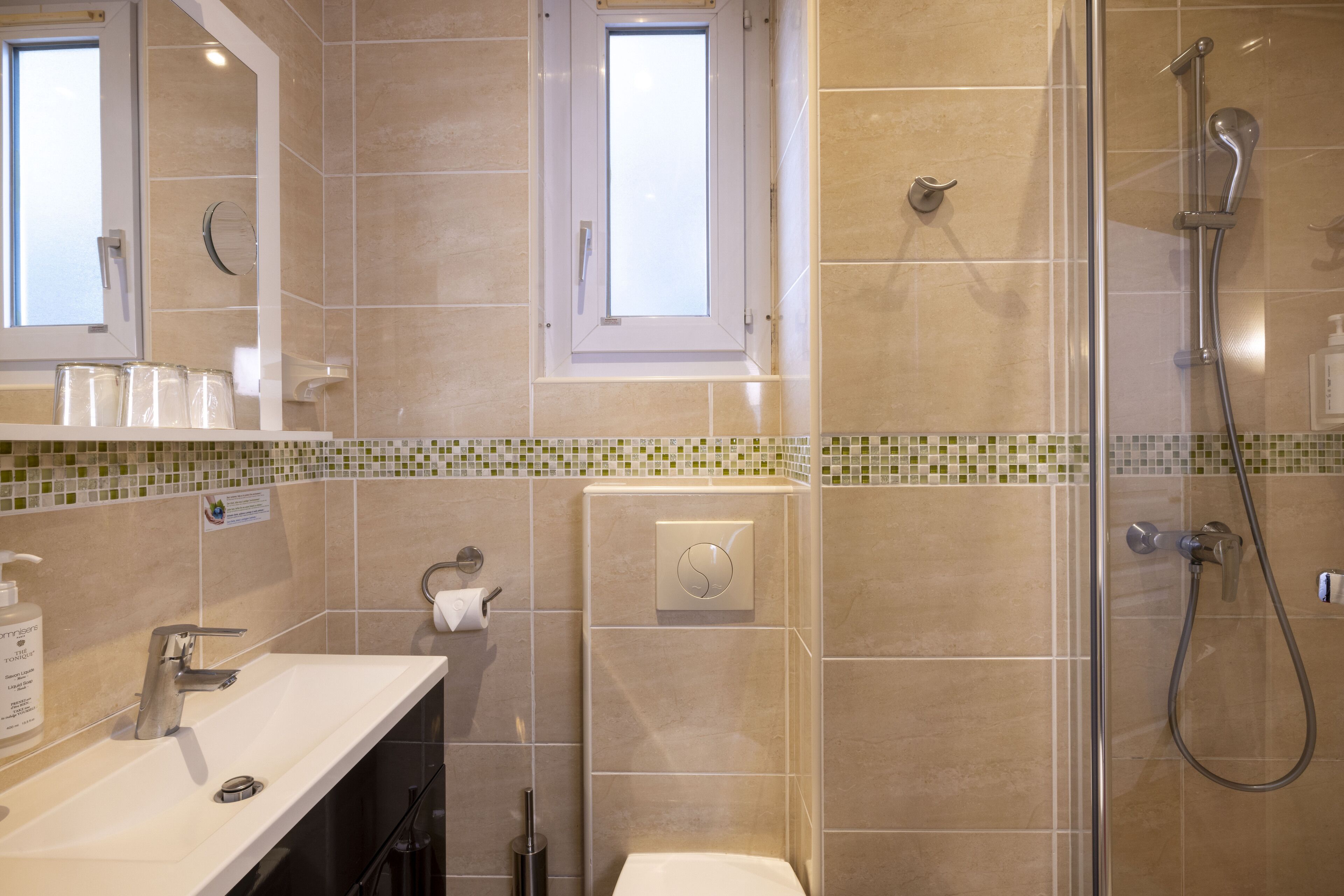 Un baño moderno con ducha, inodoro y lavamanos.