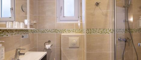 Un baño moderno con ducha, inodoro y lavamanos.