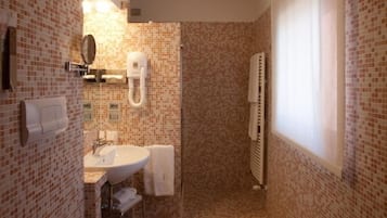 A bathroom with a tiled floor, a sink, a toilet, a mirror, and a towel rack.