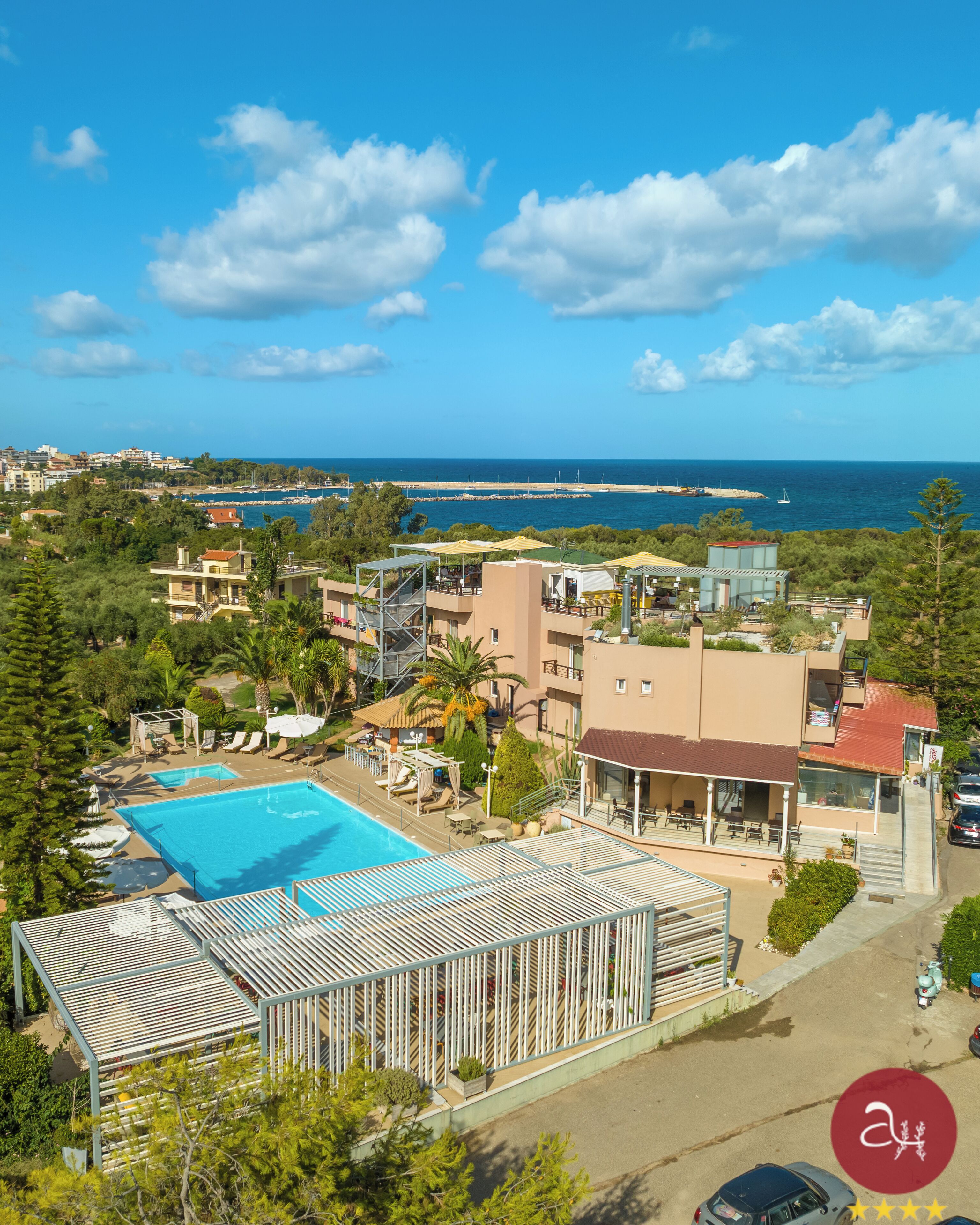 A resort with a swimming pool, beach view, and multiple buildings.