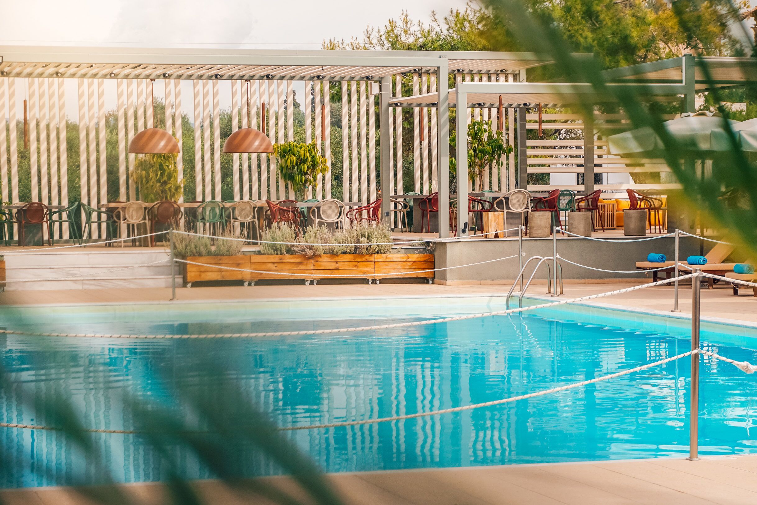 A pool area with lounge chairs and a wooden deck.