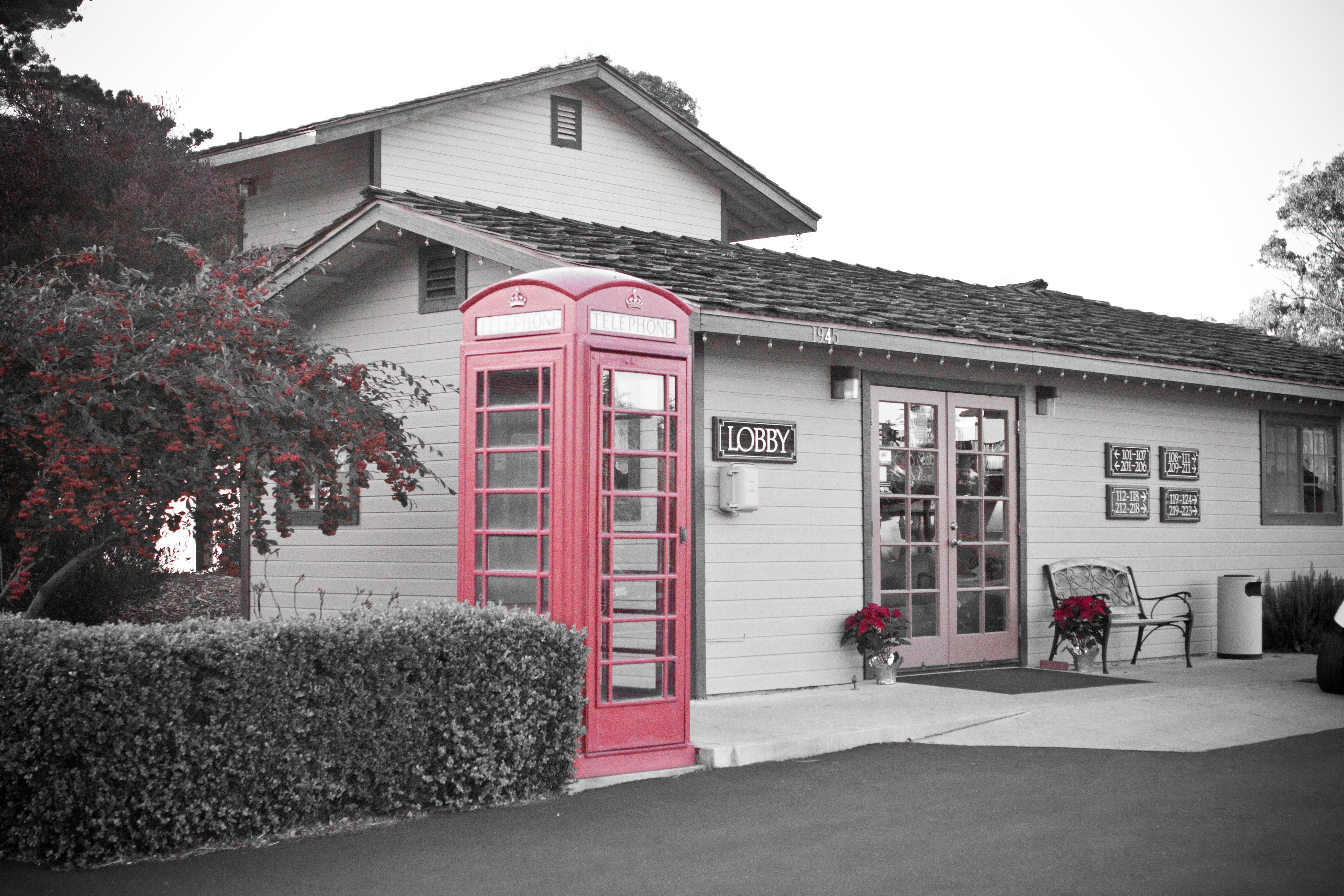A building with a red telephone booth, a sign reading "Lobby", and a bench outside.