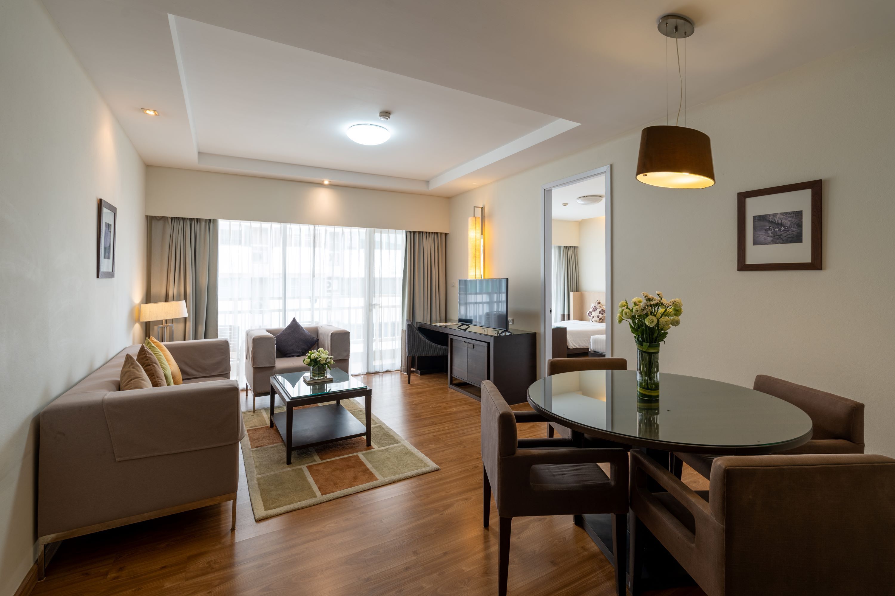 A modern living room with a sofa, coffee table, and dining area.