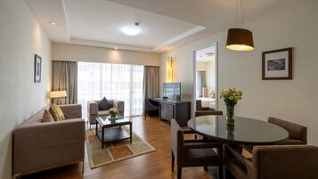 A modern living room with a sofa, coffee table, and dining area.