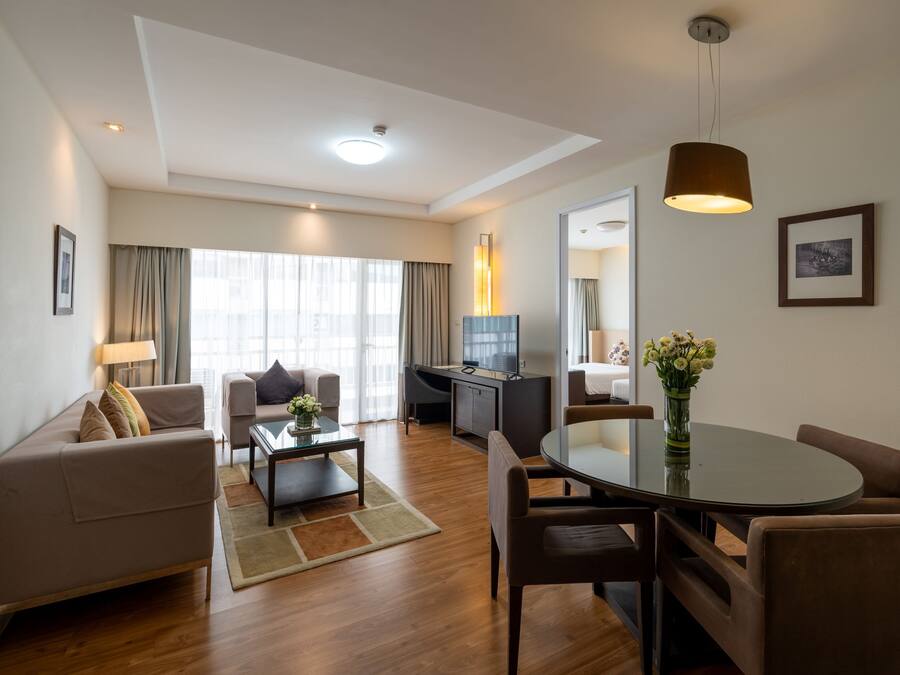 A modern living room with a sofa, coffee table, and dining area.