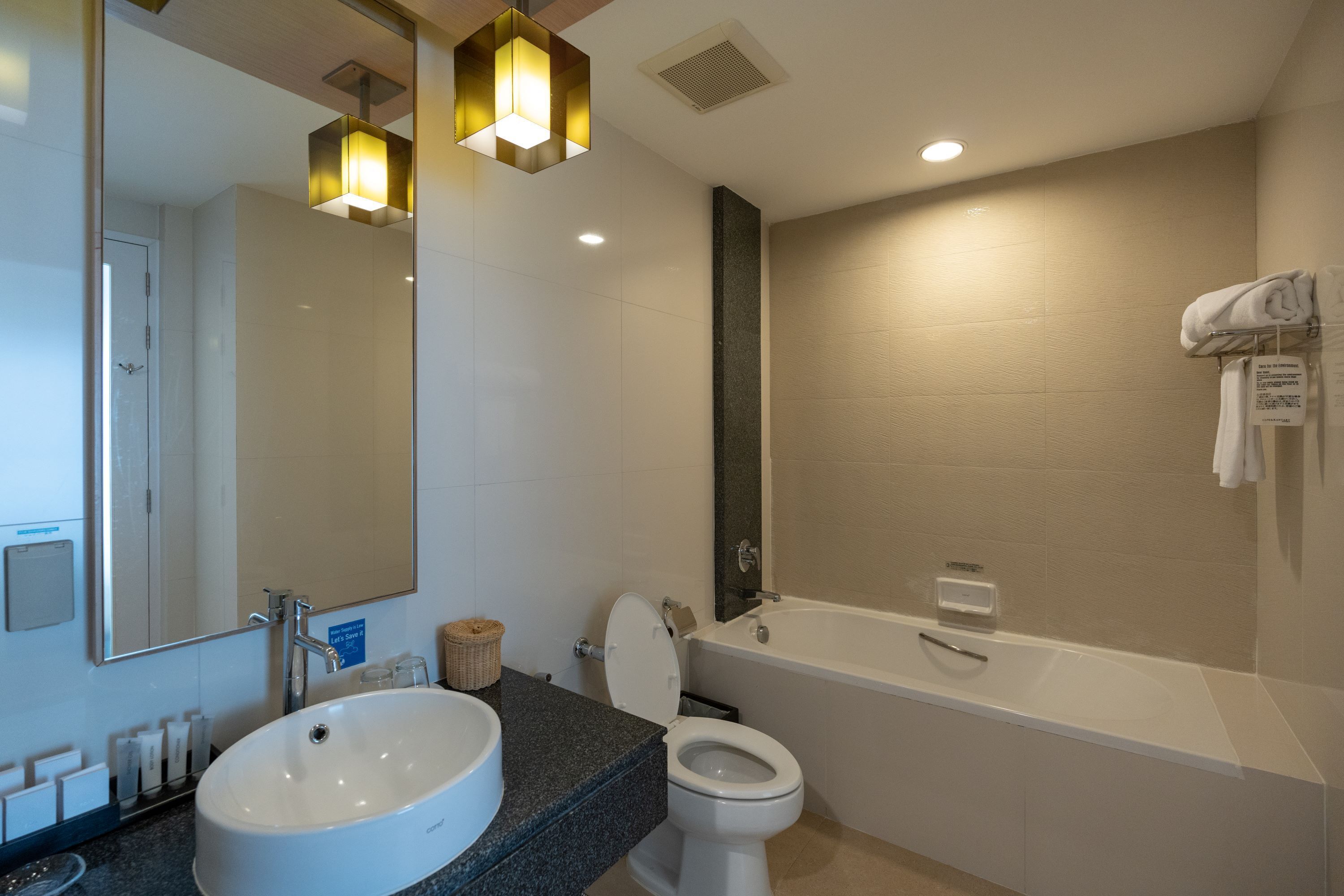 A modern bathroom with a large sink, toilet, and bathtub.