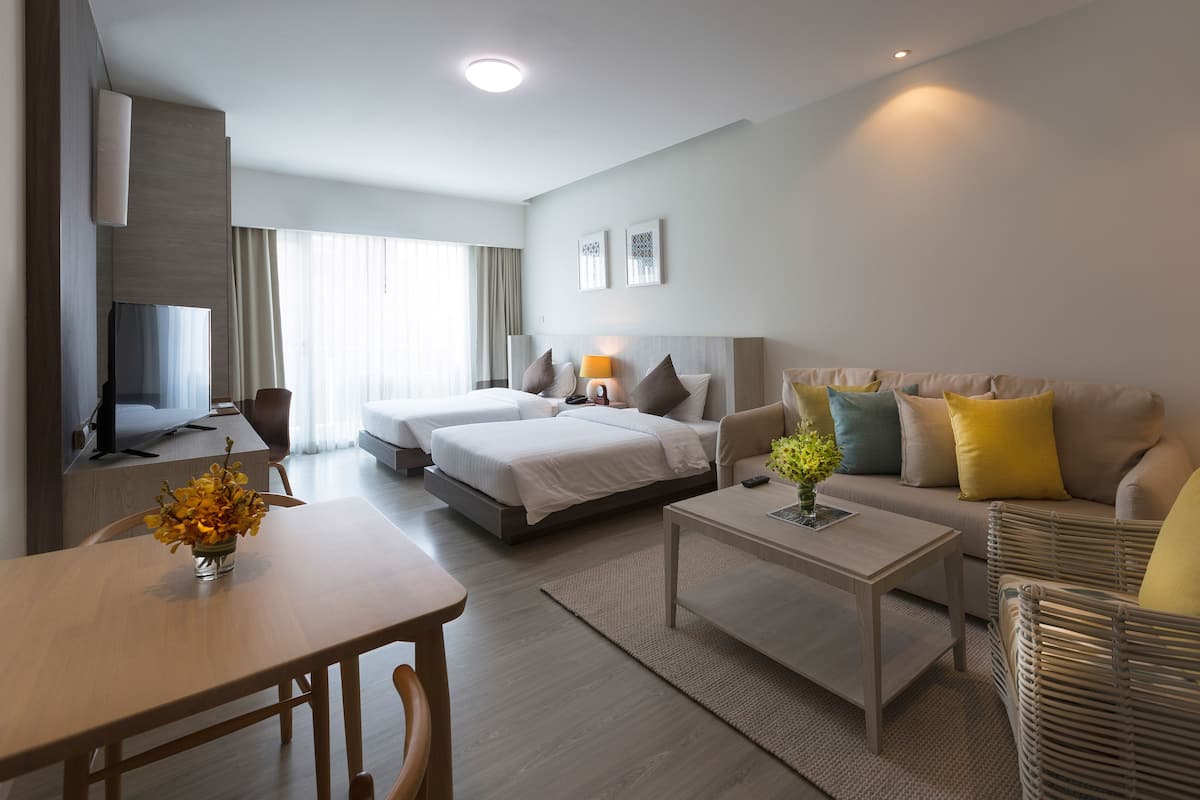 Een moderne hotelkamer met een bed, een zithoek en een eethoek.
