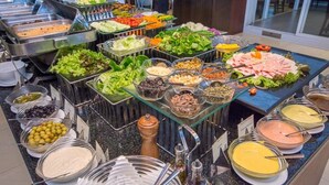 A buffet with various food items including salads, meats, and dips.