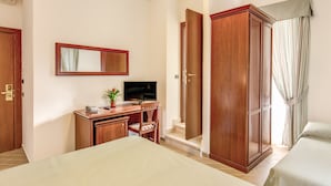 A hotel room with a bed, a desk with a TV, a wardrobe, and a shower area. - Hotel Flavio Rome (Rome)