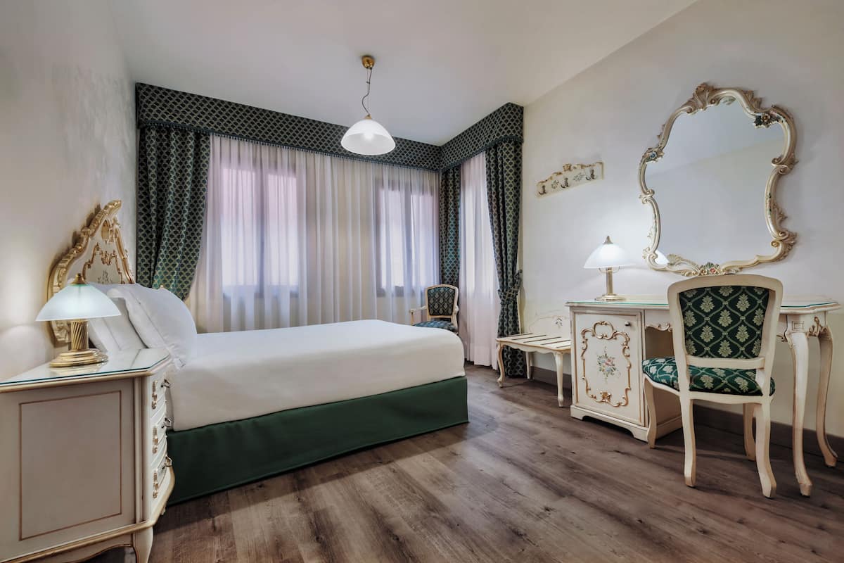 Standard dubbelrum eller tvåbäddsrum | Duntäcken, värdeförvaringsskåp på rummet och arbetsyta för laptop