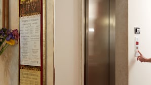 A hotel elevator with a poster advertising a concert.