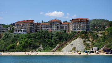 En la playa, sillas reclinables de playa, sombrillas, toallas de playa