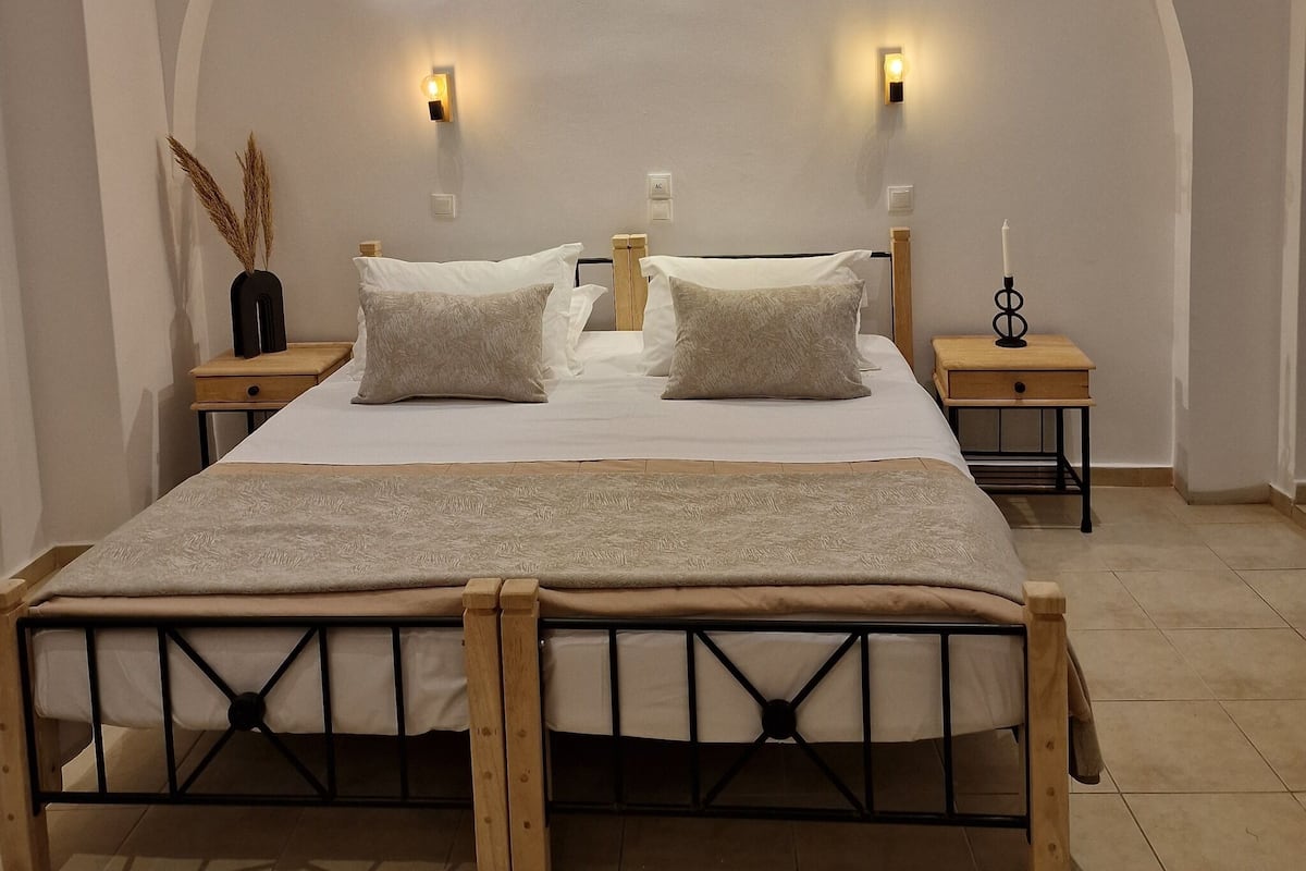 Un dormitorio con una cama grande, dos mesitas de noche y un techo curvo.