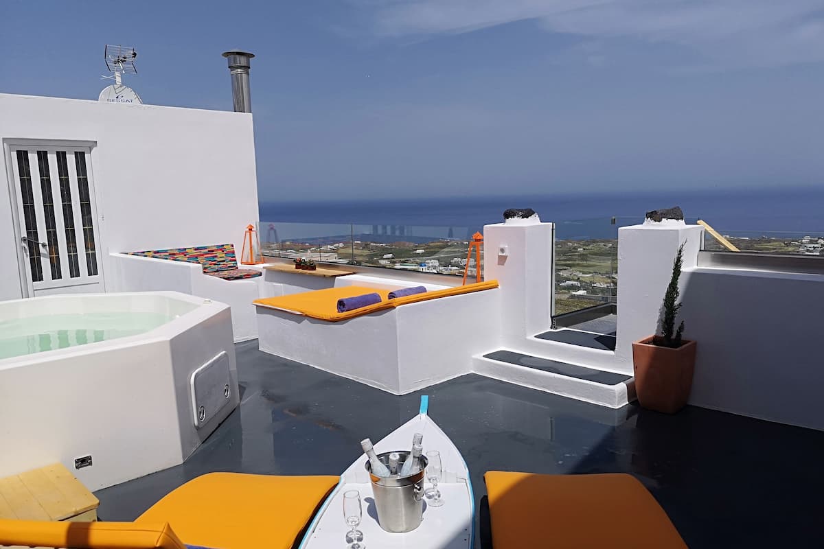 Una terraza en la azotea con hidromasaje, sillones de descanso y vistas al mar.