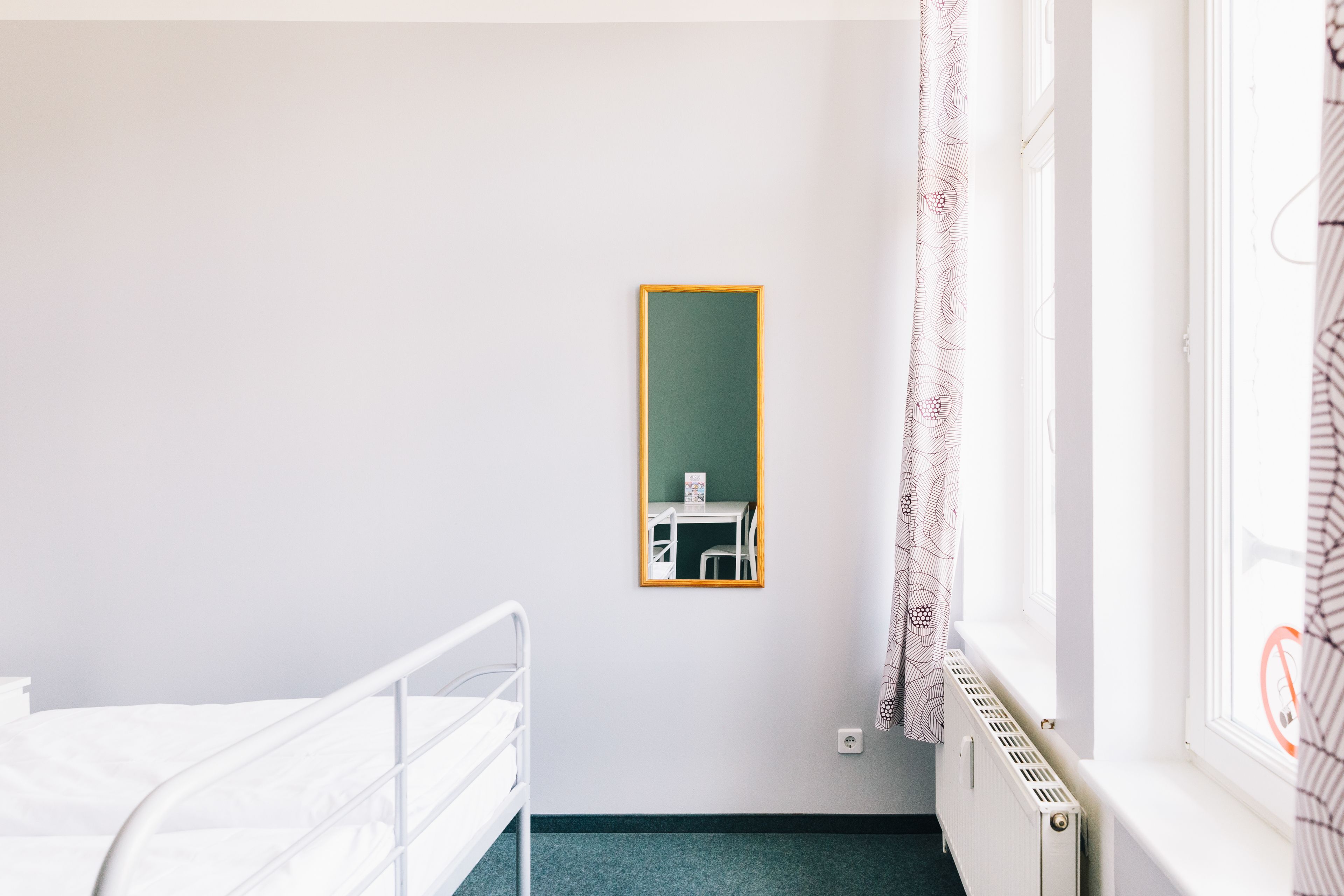 Ein Krankenhauszimmer mit einem Bett, einem kleinen Tisch und einem Stuhl.