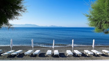 Privatstrand, schwarzer Sandstrand, Liegestühle, Sonnenschirme