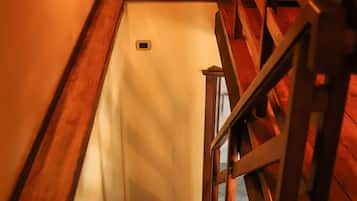 Eine Holztreppe mit Handlauf und einer Wandleuchte.