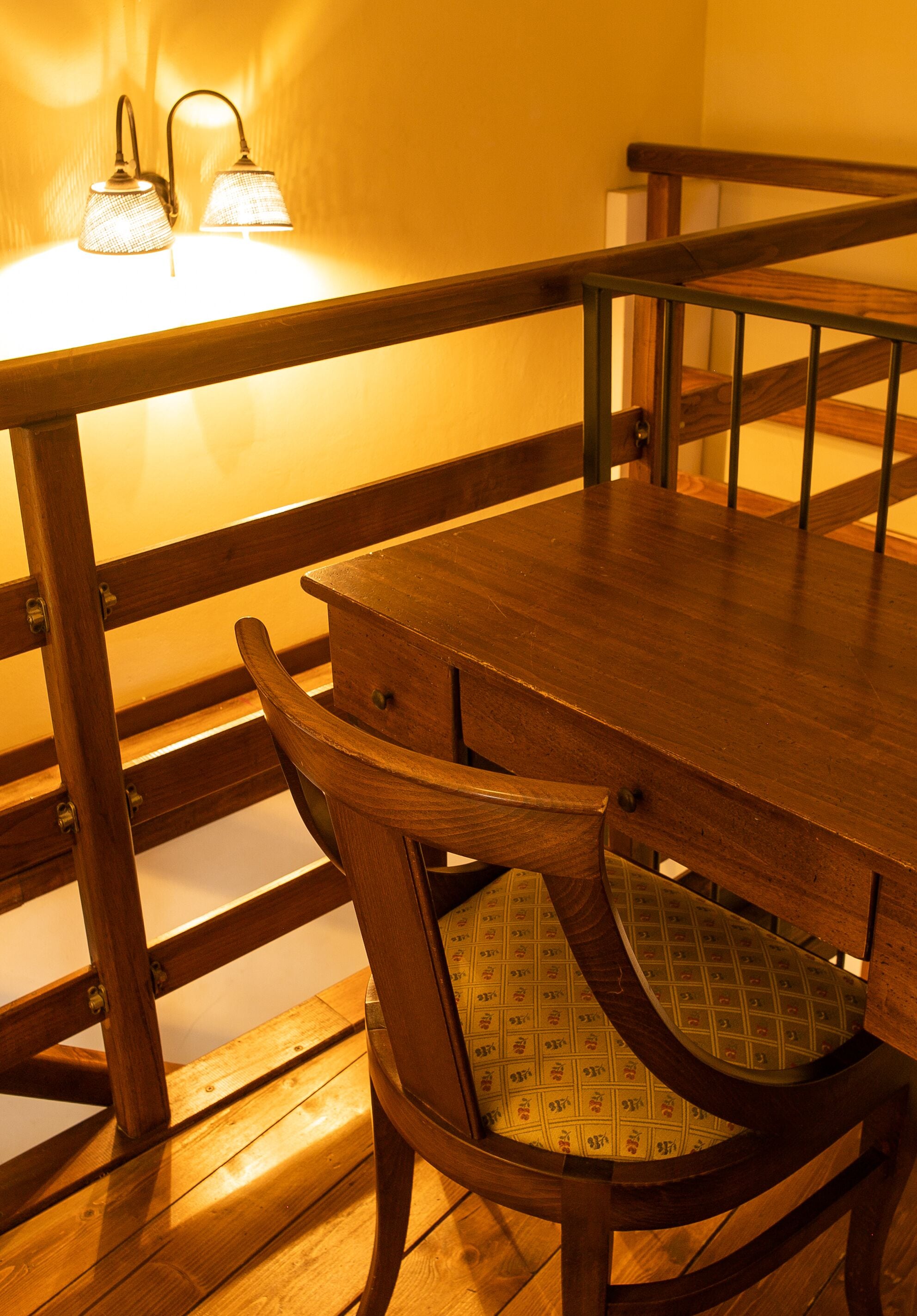 Una mesa de madera con sillas, un banco y un aplique de pared.
