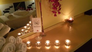 Uma área de recepção de hotel com um espelho, um aviso com a inscrição 'benhava hotel' e várias velas acesas sobre uma mesa.