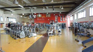 Academia com esteiras, elípticos e equipamentos de musculação.