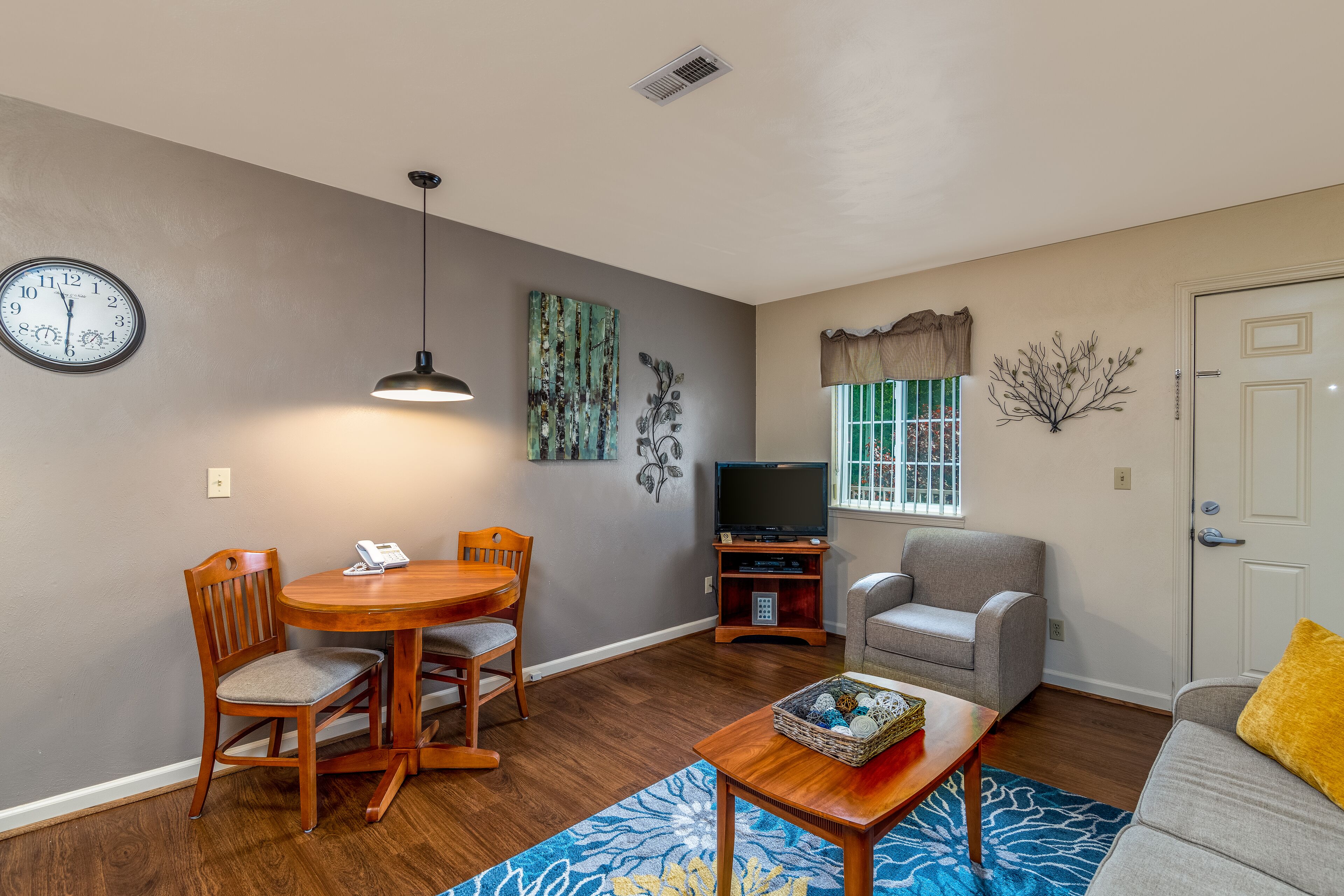 A living room with a dining table, chairs, a TV, and a sofa.