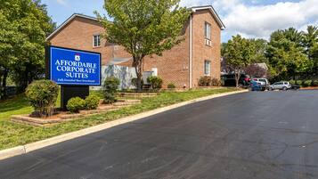 A brick building with a sign for affordable corporate suites.