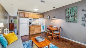 A compact living space with a kitchenette, a dining area, and a living room. - Affordable Suites of America Harrisonburg (Harrisonburg)