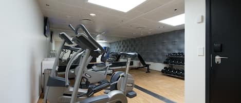 A gym with treadmills, dumbbells, and exercise machines.