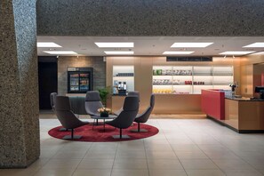 Eine Lobby mit Empfangstheke, Sitzbereich und einer Getränkekühlschrank.