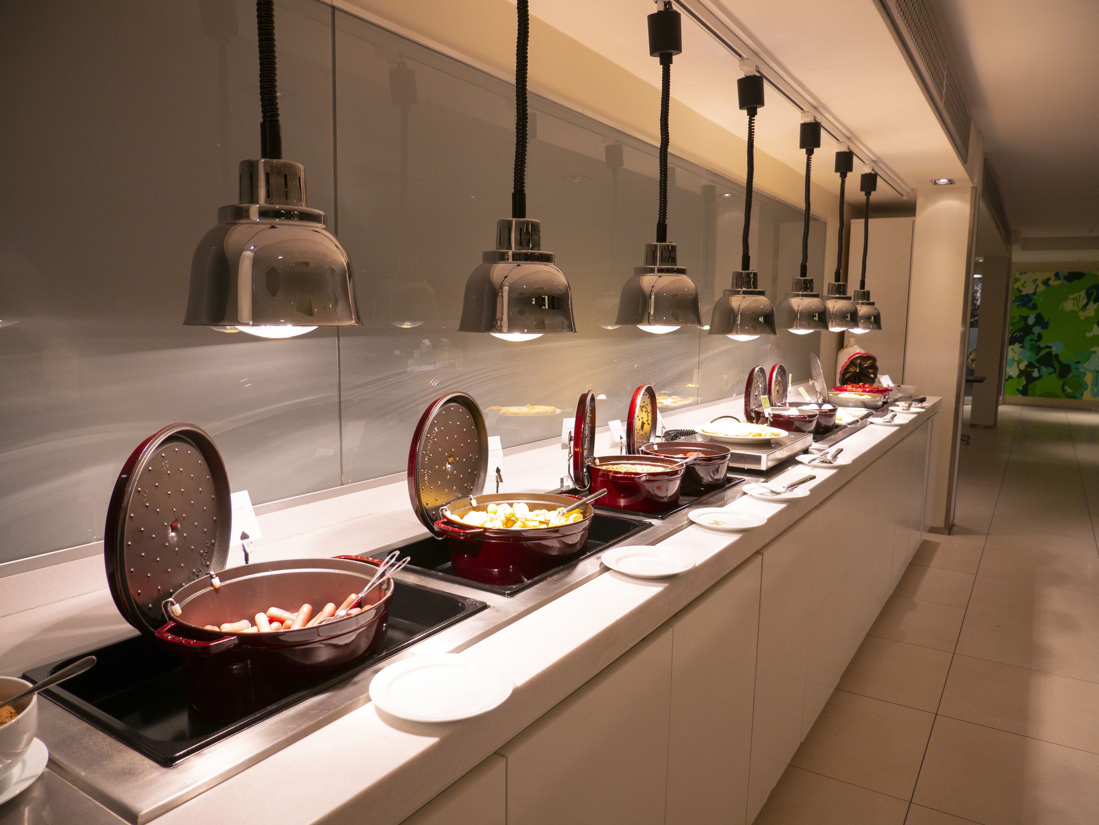 Un buffet proposant une variété de plats et d’ustensiles.