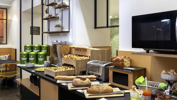 A breakfast bar with various breads, pastries, and condiments. - ibis Styles Macon Centre (Macon)
