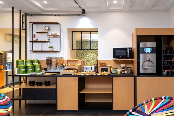 A modern kitchen with a built-in microwave, stainless steel refrigerator, and a variety of food items on the counter. - ibis Styles Macon Centre (Macon)