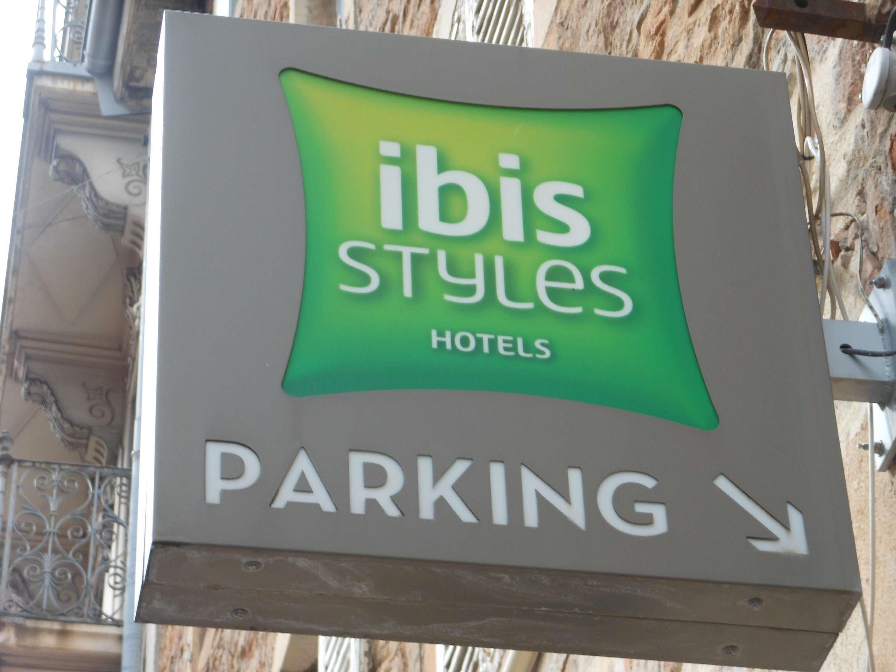 A sign for 'Ibis Styles Hotels' with a 'PARKING' arrow pointing to the right.