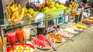 Un bufé con diversas frutas, verduras y bebidas.