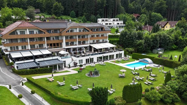 A hotel with a pool, outdoor seating, and a well-maintained lawn. - Dei Hotel Schönblick (Velden am Wörther See)