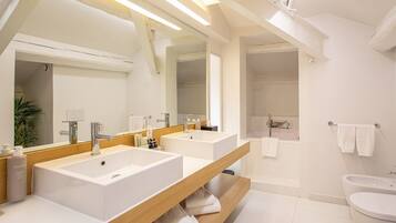 Un bagno moderno con due lavandini, uno specchio grande e una zona doccia.