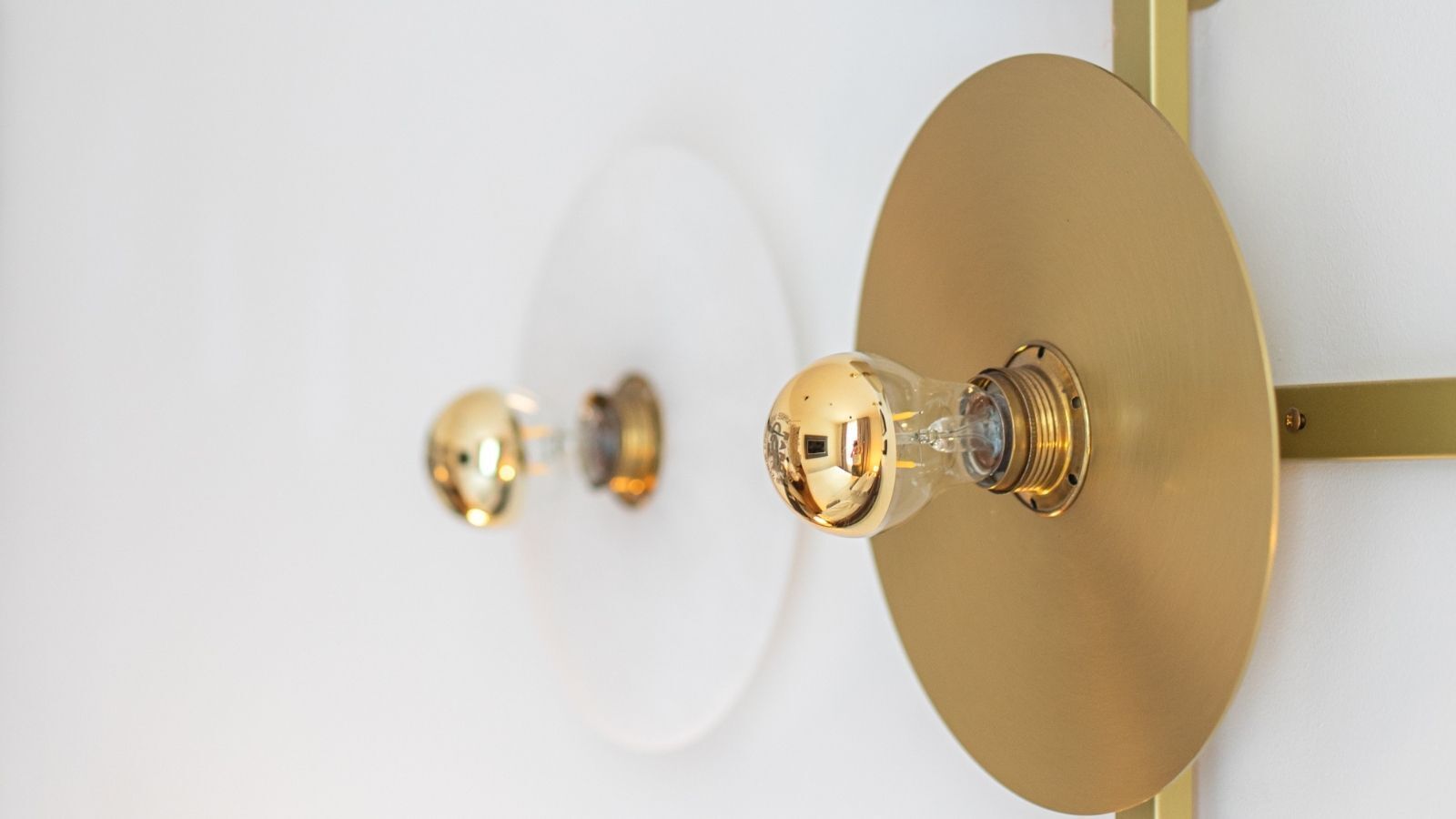 Una lámpara con bombilla de cristal esférica y base de color bronce.