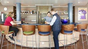 A bar area with wooden chairs and a round bar counter. - Suite - Home Orleans Saran (Saran)