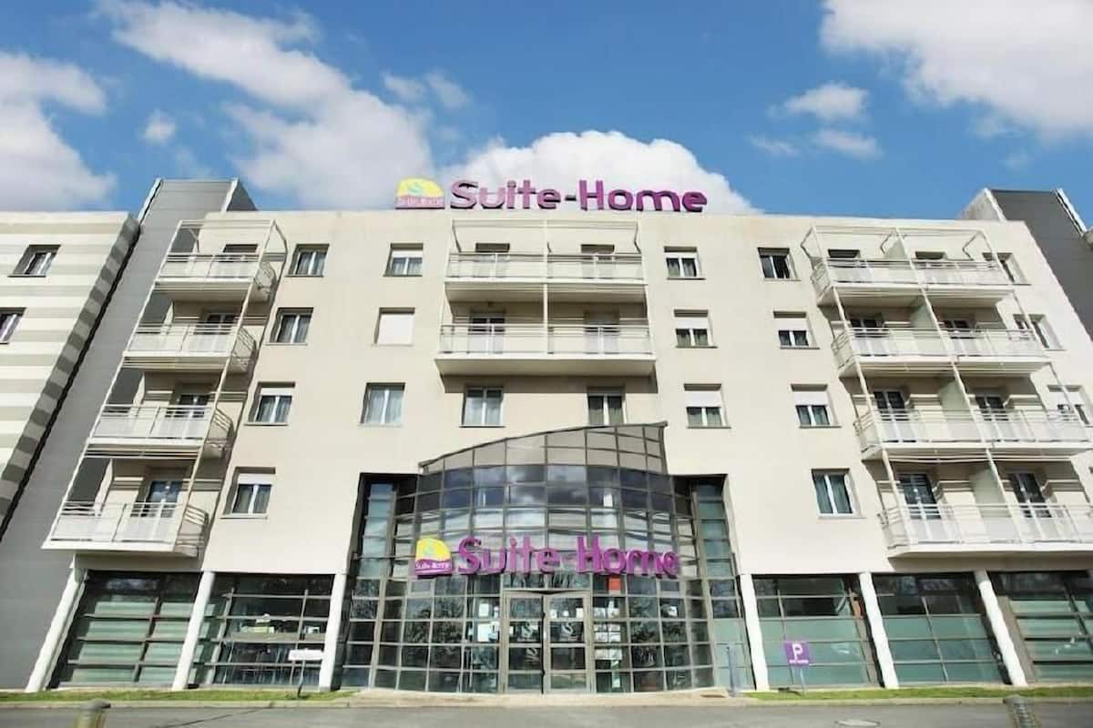 A multi-story building with the signage 'Suite-Home' indicating it is a hotel.