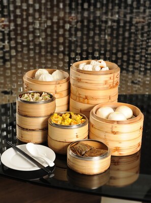 A variety of dim sum dishes in bamboo steamers on a reflective surface. - Courtyard by Marriott Hong Kong (Hong Kong)