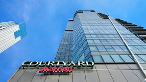 A Courtyard Marriott hotel building with a modern glass facade and a prominent signage. - Courtyard by Marriott Hong Kong (Hong Kong)