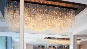 A modern lobby with a reception desk, seating area, and a patterned carpet. - Courtyard by Marriott Hong Kong (Hong Kong)