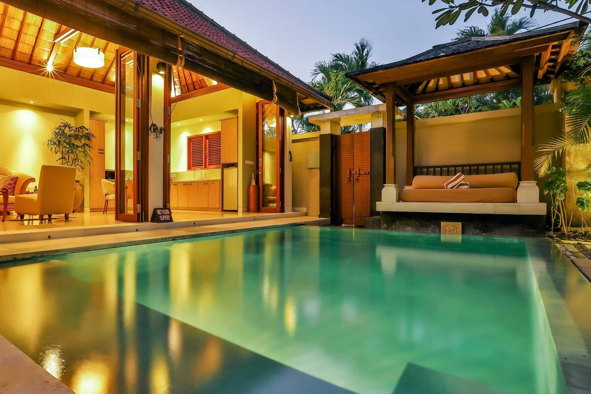 A poolside area with a lounge chair and a dining setup.